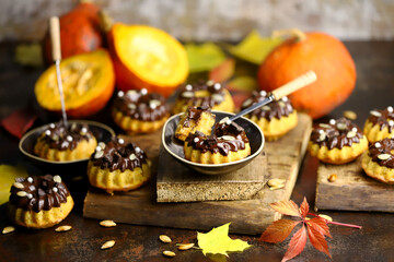 Selective focus. Pumpkin cupcakes with chocolate. Autumn desserts. Autumn still life with delicious pumpkin muffins.