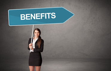 Young business person in casual holding road sign with BENEFITS inscription, new business direction concept