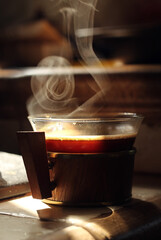 Small glass cup of hot black coffee.