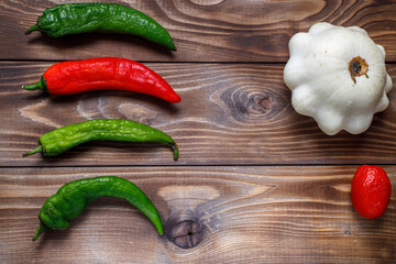 Shriveled stale peppers and squash on a wooden background. Flat layout. Space for copying. Ugly food.