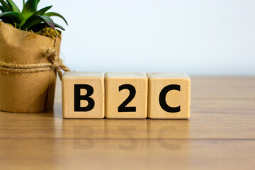 Concept word 'B2C - busines to customer' on cubes on a beautiful wooden table, white background....