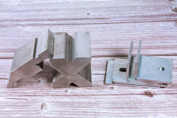 Sheet metal bending tool and equipment on a wooden background. Bend tools, press brake punch and die.