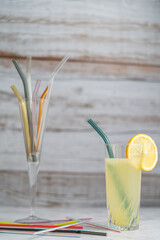 Lemonade with glass straw. Glass straws replacing plastic straws in glass with wood background and copy space.