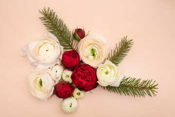 Ranunculus and rose and pine Christmas flat lay on blush background
