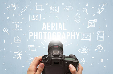 Hand taking picture with digital camera and AERIAL PHOTOGRAPHY inscription, camera settings concept