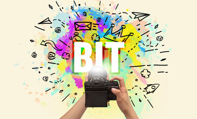 Close-up of a hand holding digital camera with abstract drawing and BIT inscription
