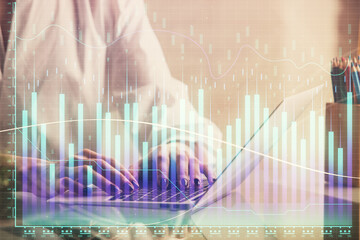 Double exposure of woman hands typing on computer and forex chart hologram drawing. Stock market invest concept.