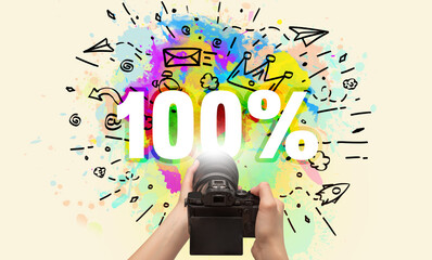 Close-up of a hand holding digital camera with abstract drawing and 100% inscription