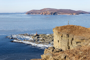 The rocky coast of Cape Tobizin on the Russian Island in Vladivostok, covered with snow and...