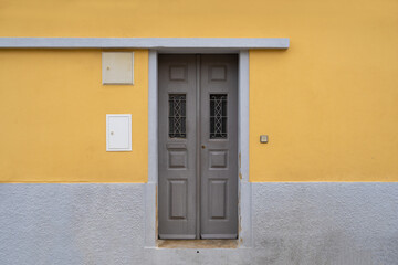 Lisbon, Portugal: yellow wall with grey wooden door