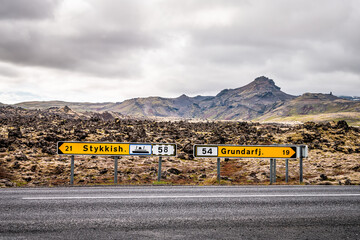 Black lava field on Snaefellsnes peninsula in Iceland with direction signs for Stykkish...