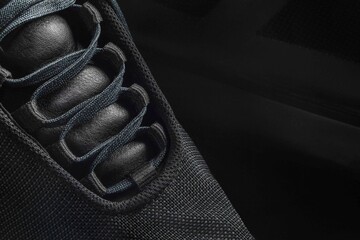 Design black sneaker on a black background. Close-up.