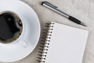 Flat Lay still life of a business desk with Coffee Cup, note book and pen.