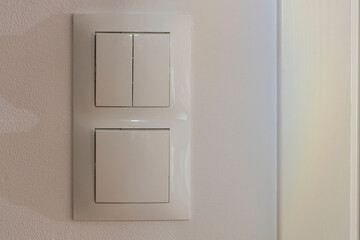 Close up view of white light switch pair on wall . Building construction elements concept. Interior. Design.