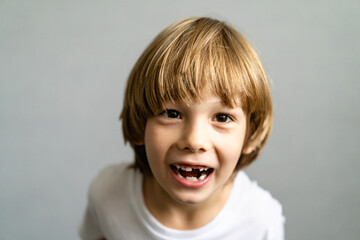 cute blonde boy without teeth, baby teeth fell out, children's medicine concept dentistry