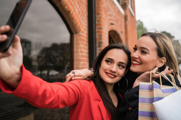 Two young friends taking a selfie with mobile phone.