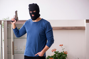 Male robber stealing valuable things from the house