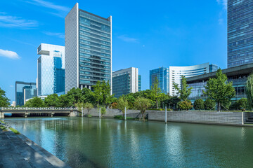 Fototapeta na wymiar modern office buildings at riverbank under blue sky in china