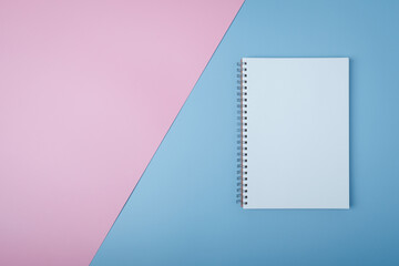 Blank spiral notebook on pastel background. Flat lay of home office desk, Office concept.