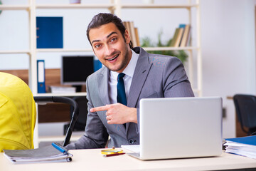 Young male employee looking after newborn at workplace