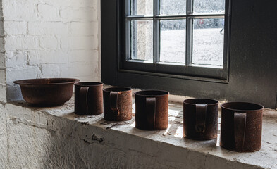 Rusty antique cups sitting in a historic home