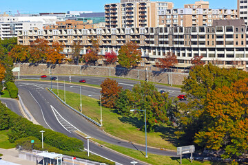 Autumn in downtown of Washington DC, USA. Trees in autumn foliage along parkway with city landscape.