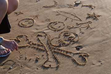 Kids drawings on the beach sand.

