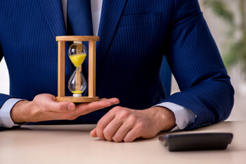 Young male employee in time management concept