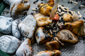 water rinse of final stage of rock tumbler over a metal screen.