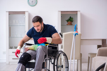 Young leg injured contractor in wheel-chair cleaning the house