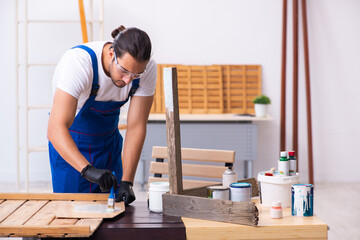 Young male contractor working in workshop