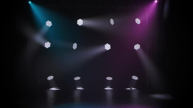 Concert lights. Lighting effects on a theater stage at night. Stage lights shine in the circus arena. Lighting equipment with multicolored beams.