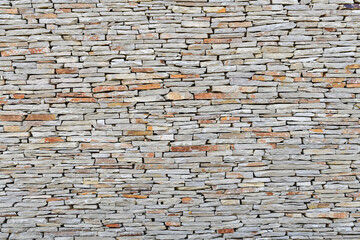 a stone wall made of small flat stones. Abstract and geometry concept.