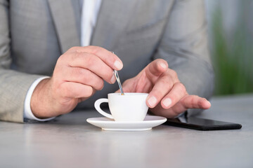 Male hands stirring a cup of coffee