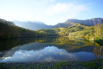 Fototapeta premium A pond that reflects trees and mountains like a mirror. At dusk. Beautiful scenery of Japan.