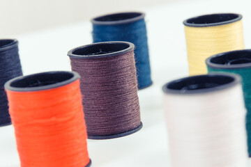 Spools of colorful thread as accessories for using in sewing.