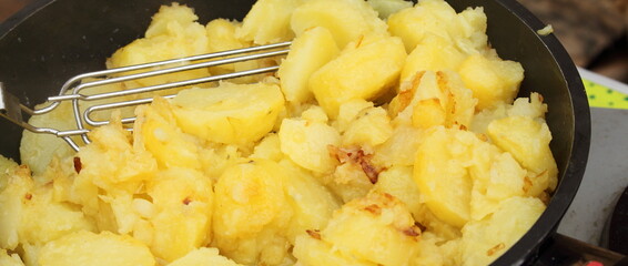 fresh fried potatoes with onions in a pan