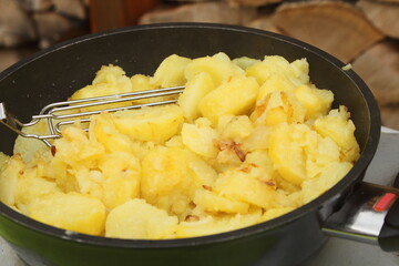 fresh fried potatoes with onions in a pan