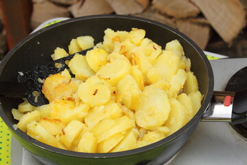 fresh fried potatoes with onions in a pan