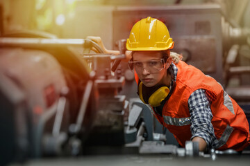 Female engineers and specialists in auto parts manufacturing are producing auto parts at a machine...