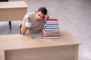 Young male student preparing for exams at library