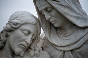 Close up of Jesus and Mary in cemetery pieta statue. Full frame in matural light with copy space