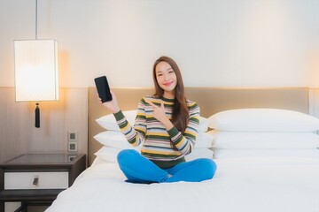 Portrait beautiful young asian woman using smart mobile phone on bed