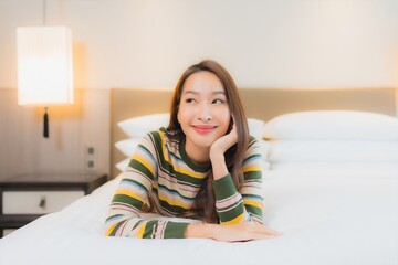 Portrait beautiful young asian woman smile happy relax on bed