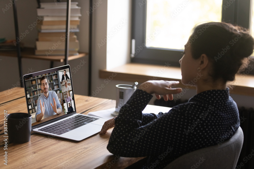 Poster female employee talk speak on video call on laptop with diverse multiracial colleagues coworkers at 