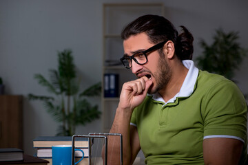 Young male student physicist working hard at night time