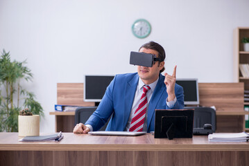 Young male employee wearing virtual glasses in the office