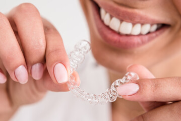 girl with a beautiful smile holding a transparent mouth guard