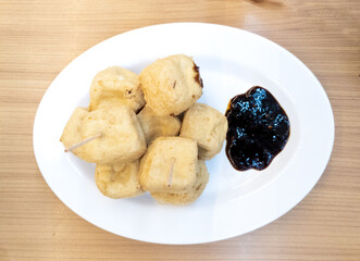 Fried tofu on a plate for snacks. Asian food served with soy sauce in the restaurant.