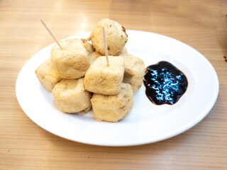 Fried tofu on a plate for snacks. Asian food served with soy sauce in the restaurant.